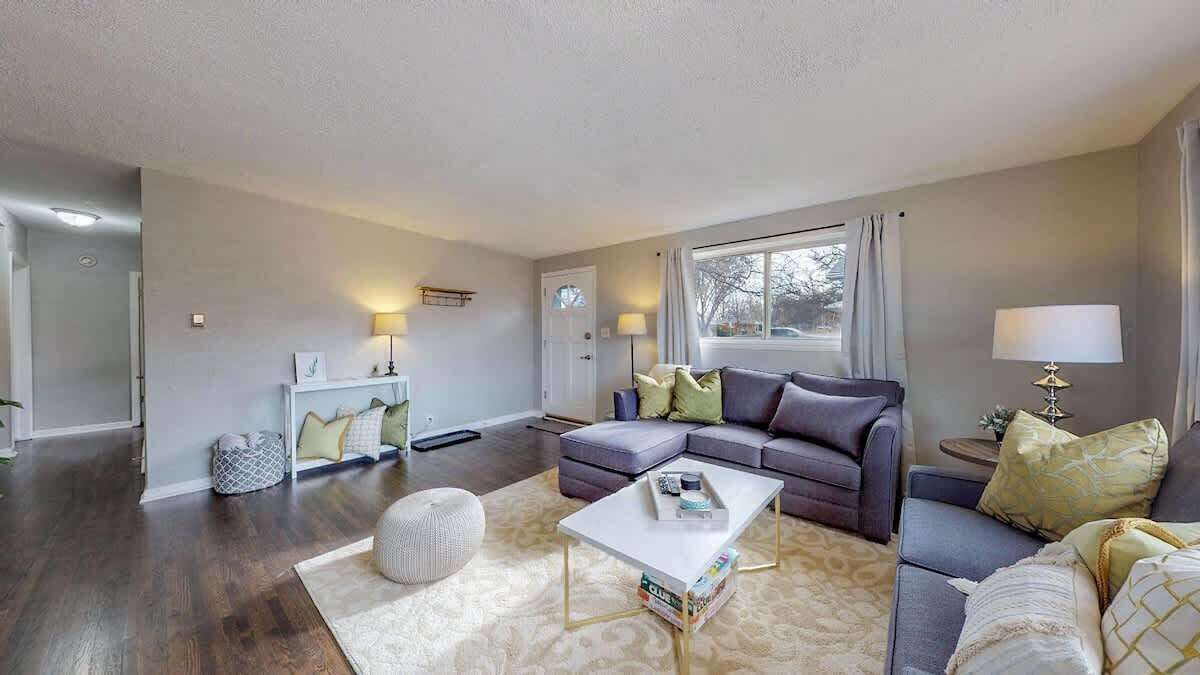 Un salon moderne avec un canapé, une table basse et un tapis.