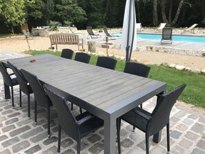 A patio with a long table and chairs, a pool, and lounge chairs. - traditional Landes house 16 people spa, swimming pool, billiards (Cachen)
