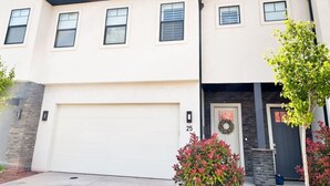 Ein zweistöckiges Haus mit Garage, einer Haustür mit Weihnachtskranz und der Hausnummer 25 an der Garagentür.
