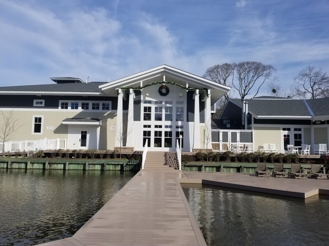 Un edificio con un ingresso centrale, una tettoia e un elemento d'acqua di fronte.
