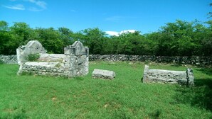 An outdoor historical site with stone ruins and a stone wall.