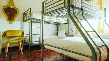 Quarto com beliche, piso de madeira, uma cadeira amarela e espelho na parede.