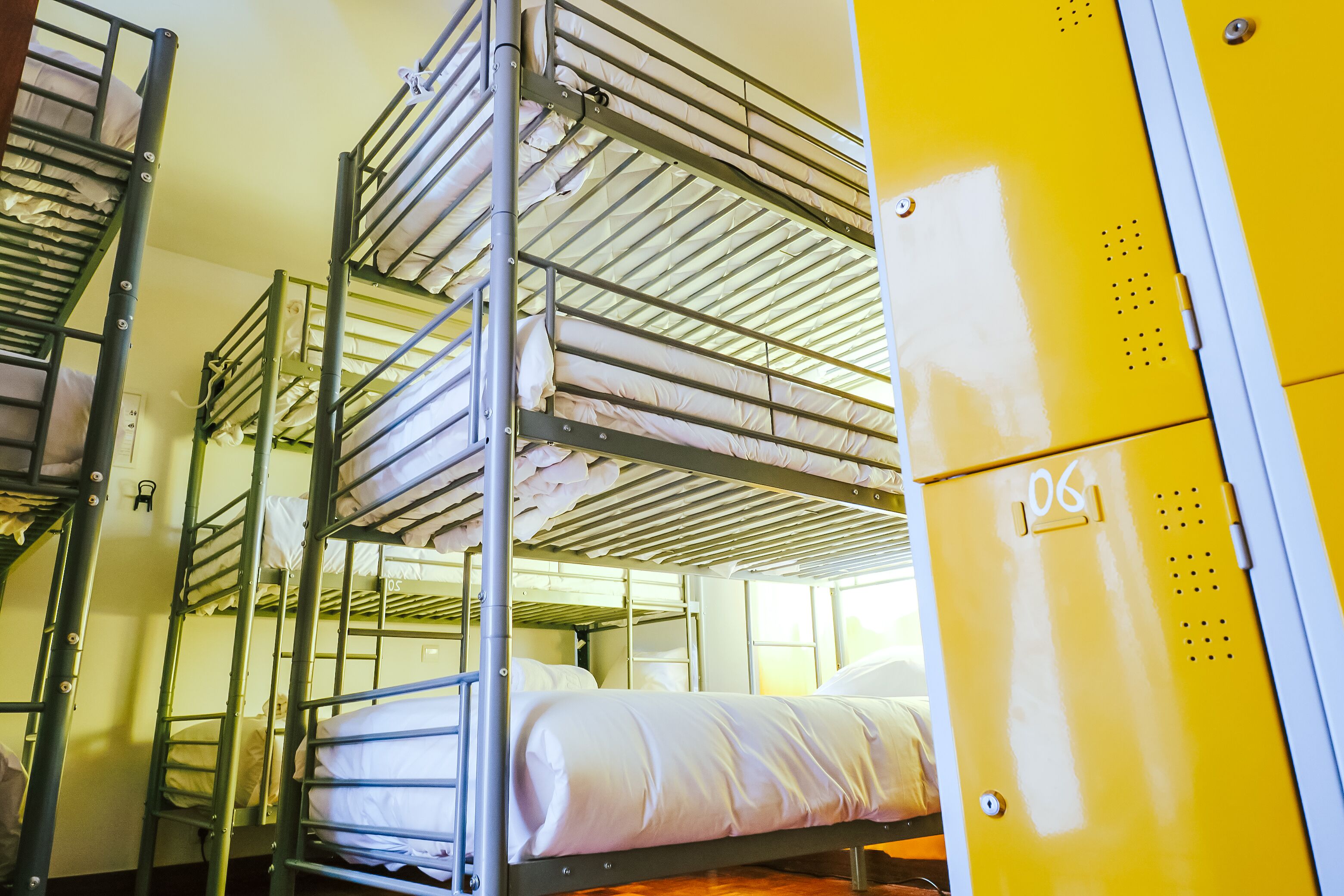 A bunk bed room with metal railings and a yellow storage unit.