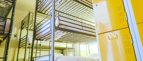 A bunk bed room with metal railings and a yellow storage unit.