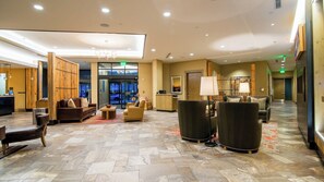 A spacious lobby with a reception desk, seating area, and a view of the street through the glass doors. - Avon Colorado | Friends Ski Retreat | Hot Tub + Ski | 2BR (Avon)