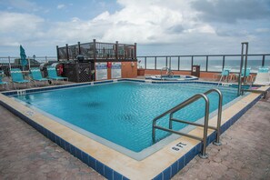 A swimming pool with a 6 ft depth, surrounded by lounge chairs and a deck area.