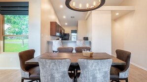 A modern dining area with a wooden table and grey upholstered chairs.