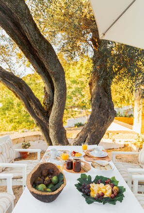 A table set outdoors with a view of trees and a white umbrella. - Quinta do Valdalágea (Lamego)