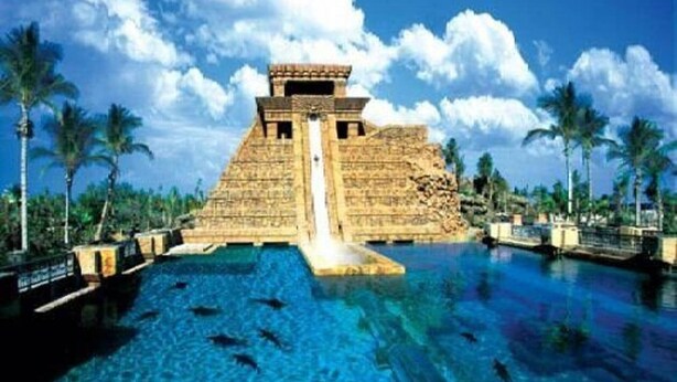 A large outdoor swimming pool with a pyramid structure in the background.