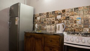 Eine Küche mit Kühlschrank, Herd, Holzschränken und einer Wand voller Kaffee- und Lebensmittelaufkleber.