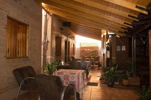 Un comedor interior acogedor con paredes de ladrillo, vigas de madera y mesas dispuestas para comer.