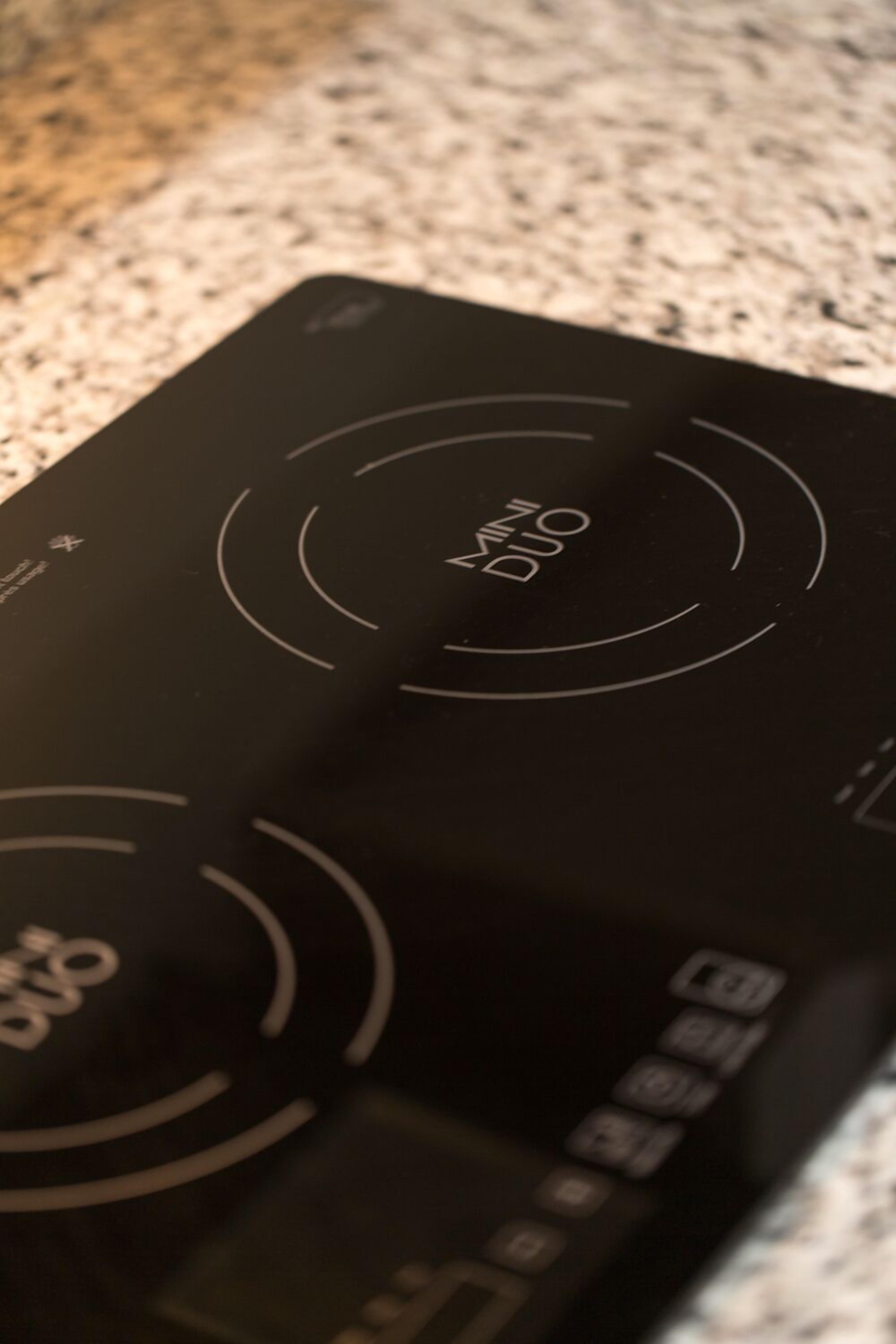 A black induction cooktop with the label "MINI DUO" and control buttons.
