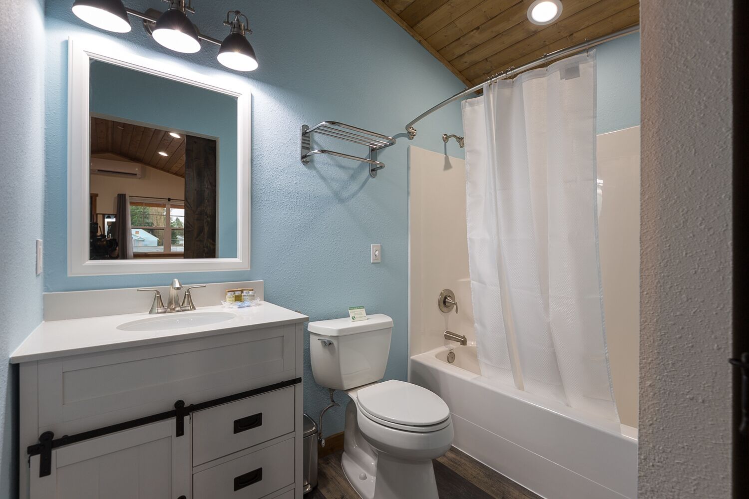 A bathroom with a white sink, a toilet, and a bathtub with a shower curtain.