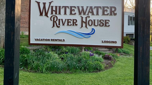 Letrero de Whitewater River House, que indica que ofrece alquileres vacacionales y alojamiento.