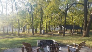 Un camping con dos sillas Adirondack y un brasero.