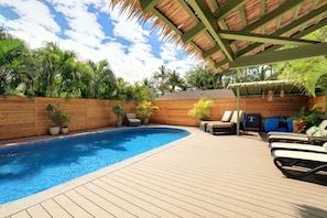 A wooden deck with a swimming pool, lounge chairs, and potted plants. - Spacious Maui Beach House, Private Pool, AC, Sleeps 6 (Kihei)