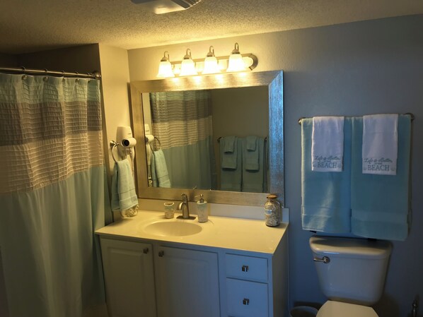 Une salle de bain équipée d’un lavabo, d’un miroir et d’un porte-serviettes.