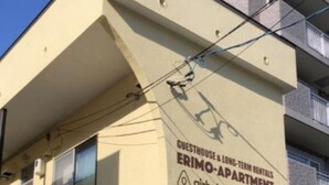 A building with a sign indicating it is an Airbnb long-term rental guesthouse and apartment.