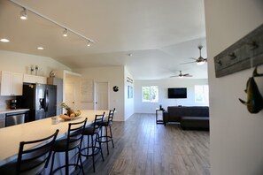 A spacious kitchen with a central island, bar stools, and a dining area. - Gorgeous Ocean View, Comfortable Cool Elevation, Close to Everything! (Kailua-Kona)