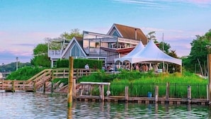 A waterfront property with a dock, a covered pavilion, and a building with multiple levels and balconies.