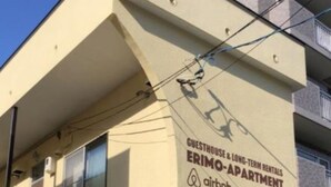 A building with a sign indicating it is a guesthouse and long-term rental apartment, associated with Airbnb. - Sapporo Apartment 203 (Sapporo)