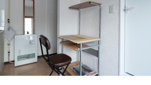 A room with a desk, chair, and a radiator. - Sapporo Apartment 203 (Sapporo)