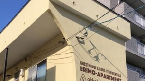A building with a sign for "Guesthouse & Long-Term Rentals" and "Airbnb" indicating available accommodations. - Sapporo Apartment 207 (Sapporo)