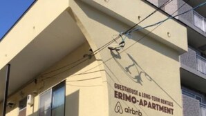 A building with a sign for "Guesthouse & Long-Term Rentals" and "Erimo-Apartment" by Airbnb. - Sapporo Apartment 105 (Sapporo)