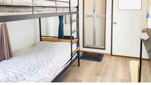 A bunk bed room with a desk and a door. - Sapporo Apartment 0 (Sapporo)