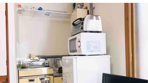 A compact kitchen with a microwave, toaster, and refrigerator. - Sapporo Apartment 1 (Sapporo)