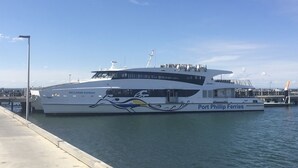 A large white yacht docked at Port Phillip Ferries with a distinctive blue and yellow design on its side. - Bellarine Spa Wellness & Retreat (Portarlington)