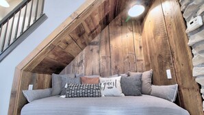 A cozy bedroom with a sloped ceiling, a bed with patterned bedding, and a wooden headboard. - The St. Charles Guest House, lovely historic home, fun for families and groups (St. Charles)