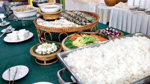 A buffet table with various dishes including rice, vegetables, and seafood. - Grand Visanu Hotel (Nakhon Sawan)