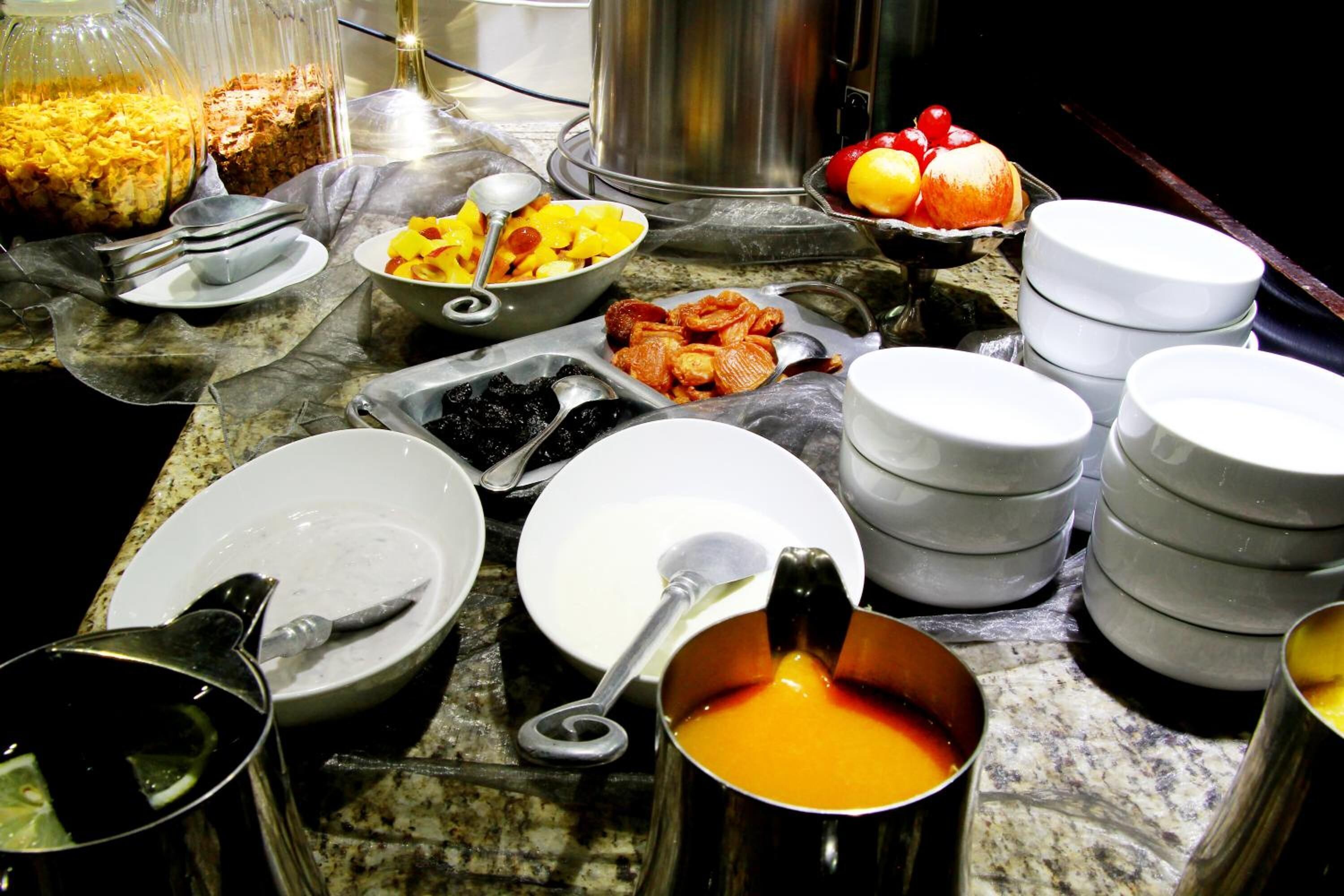 Una mesa de buffet con diversos alimentos y utensilios para servir.