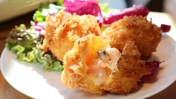 A plate with a breaded and fried food item, possibly chicken, with a visible egg yolk, accompanied by a side salad.