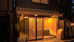 A two-story building with a traditional Japanese architectural style, featuring a wooden facade and sliding doors. - Connect Inn Shichijokamogawa (Kyoto)