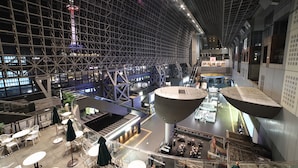 A spacious indoor area with multiple seating areas, a large central structure, and a staircase leading to an upper level. - Kanade Kujoaketachobettei (Kyoto)