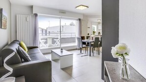 A modern living room with a sofa, coffee table, and dining area. - La Closerie des Tremieres by Interhome (Saint Georges de Didonne)