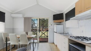 Una cocina moderna con comedor, televisor y un amplio ventanal.