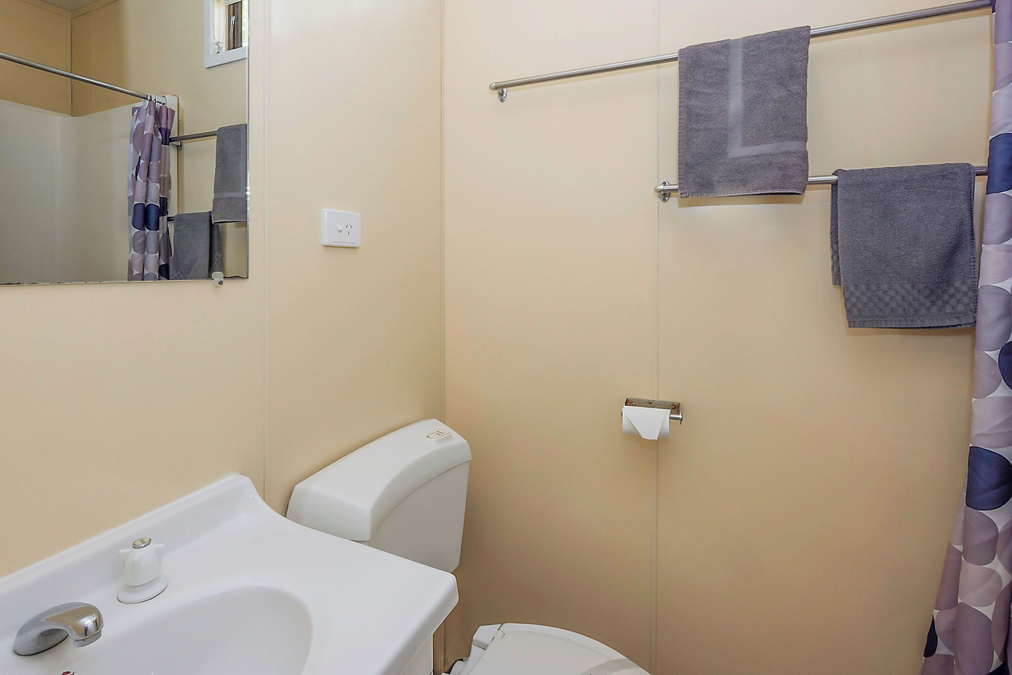 Ein Badezimmer mit Waschbecken, Toilette und Handtuchhalter.
