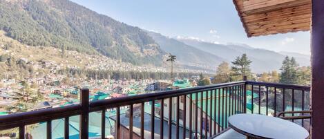 A balcony with a view of a town and mountains.