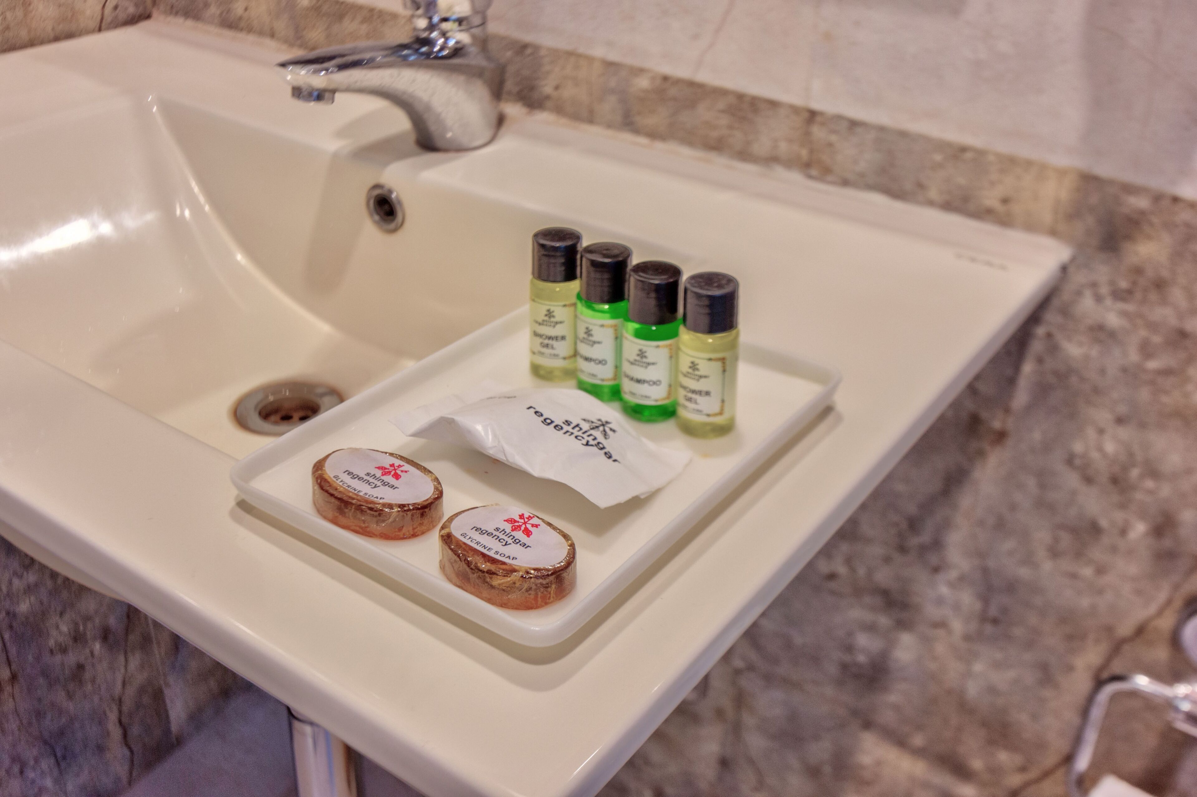 A bathroom sink with toiletries including shampoo, conditioner, and soap.