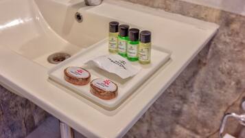 A bathroom sink with toiletries including shampoo, conditioner, and soap.