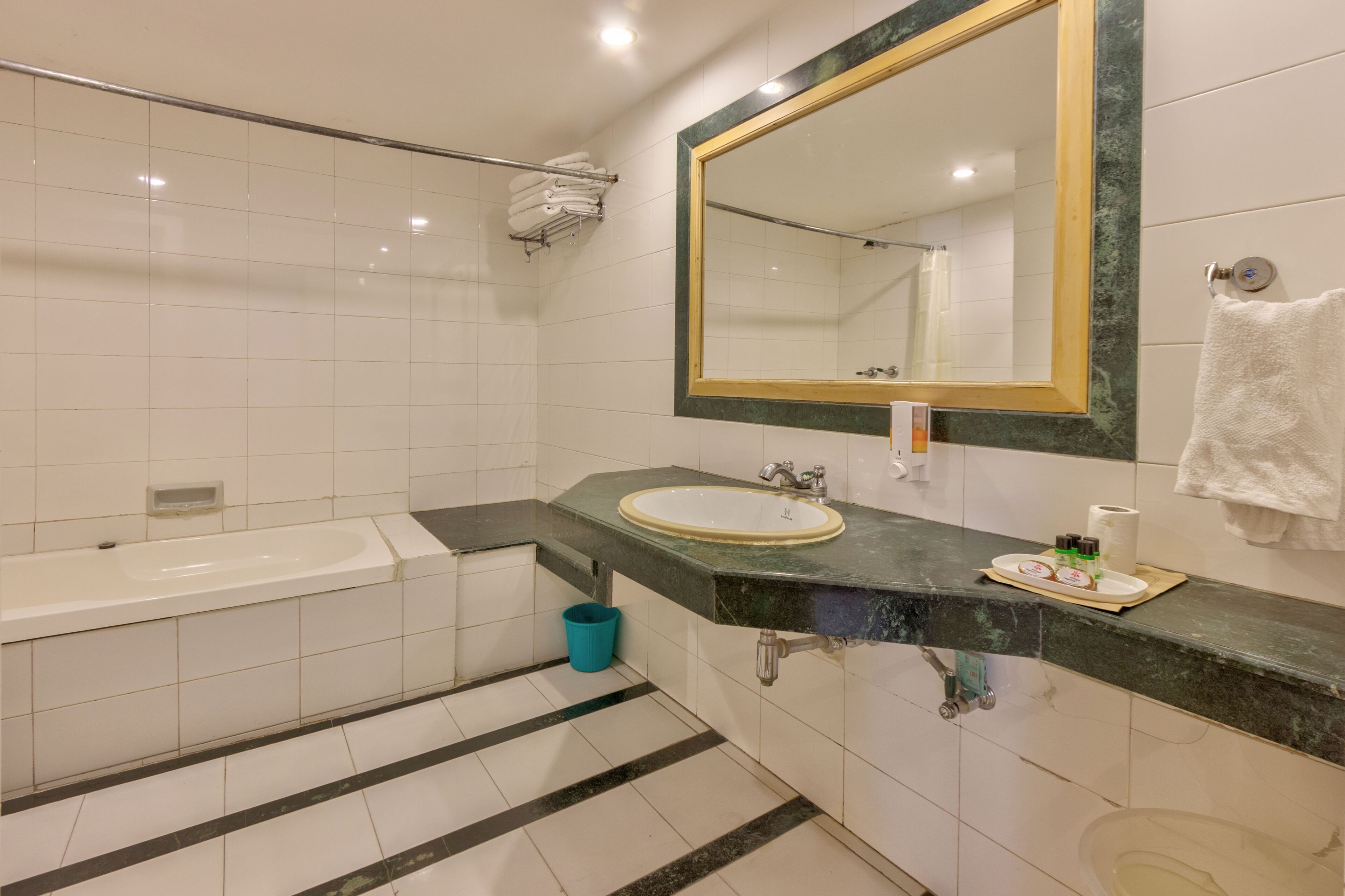 Un baño moderno con bañera, lavamanos y un espejo grande.