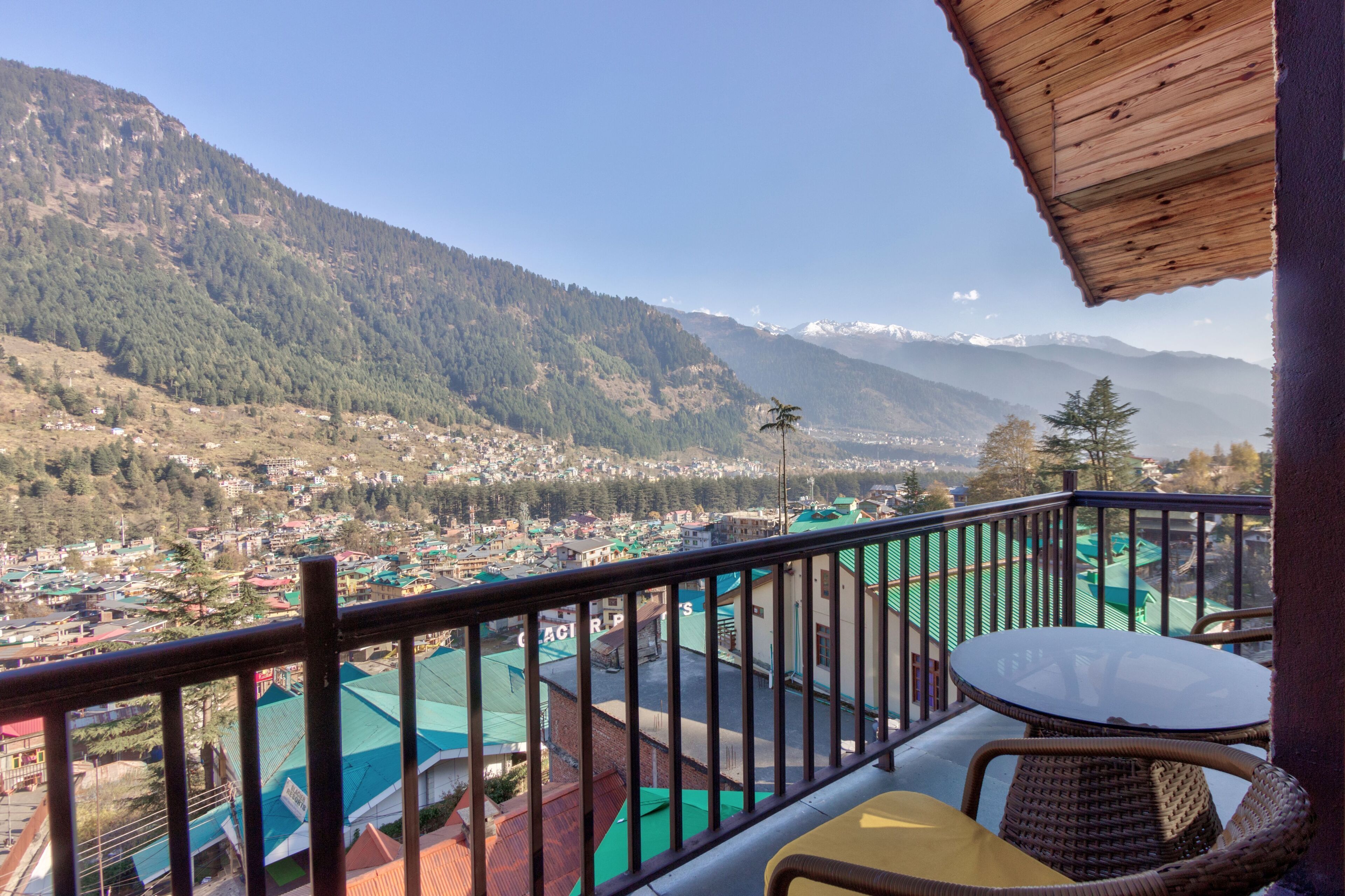 A balcony with a view of a town and mountains.