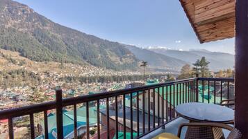 A balcony with a view of a town and mountains.