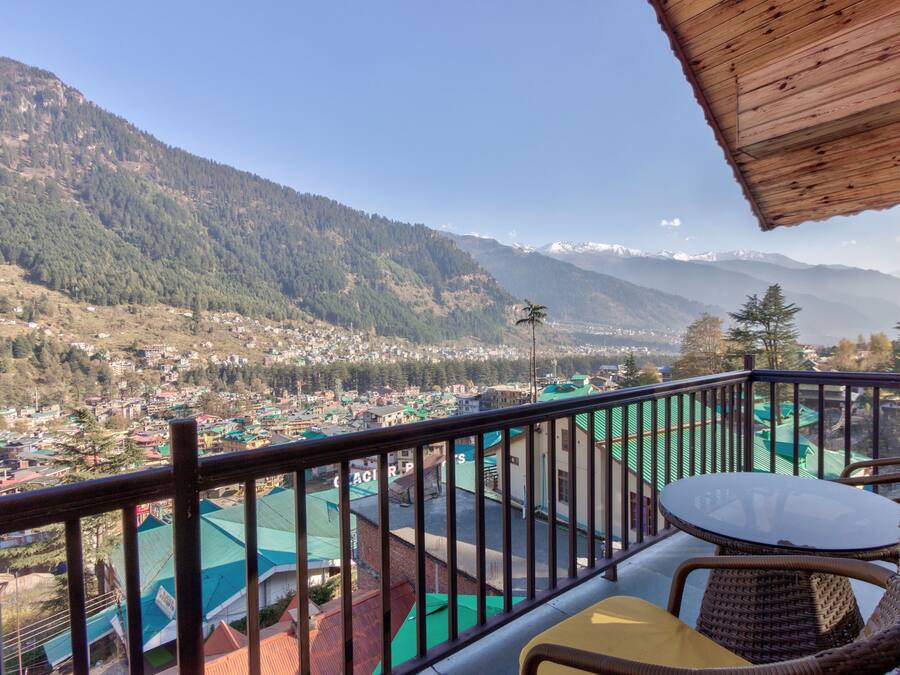 A balcony with a view of a town and mountains.