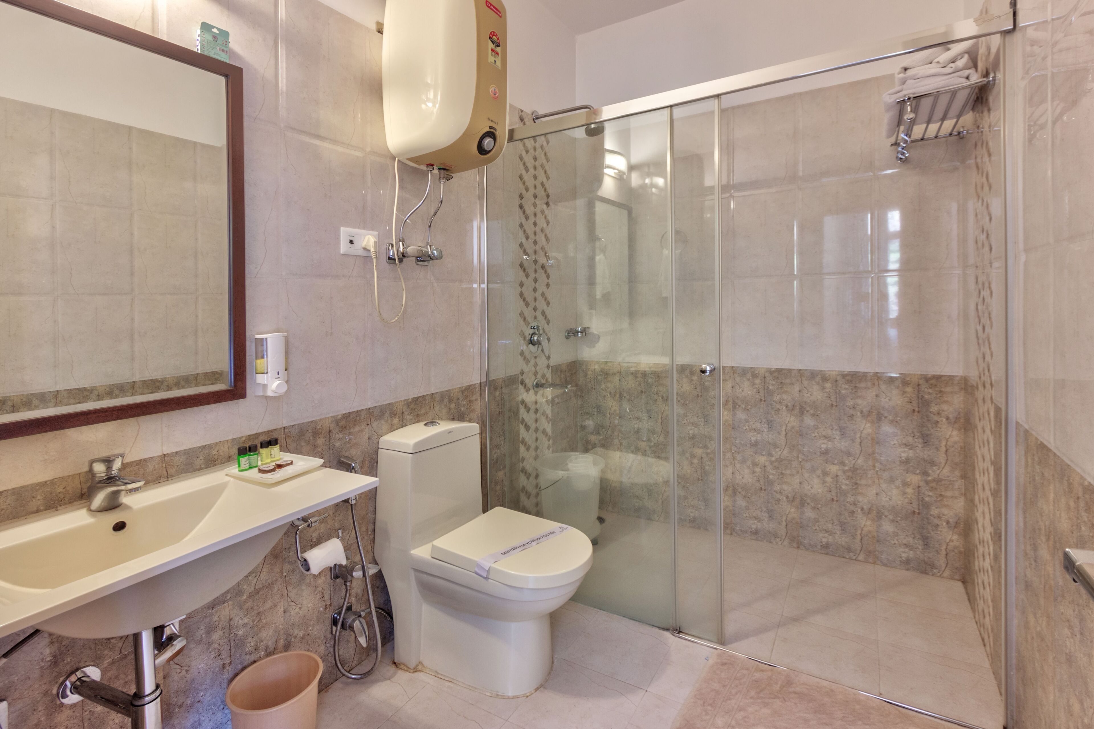 A modern bathroom with a glass-enclosed shower, a sink with a mirror, and a toilet.