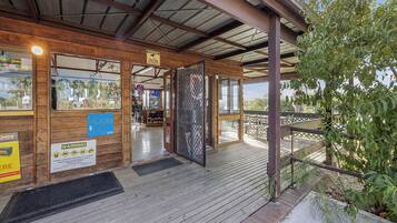 A wooden building with a covered entrance, a warning sign, and a view of the surrounding area.