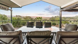 A covered outdoor seating area with a table and chairs, overlooking a scenic landscape. - Reflections Lake Burrendong - Holiday Park (Mumbil)